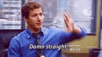 a man in a blue shirt and tie is sitting in front of a window and saying damn straight .