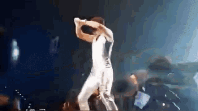a man is dancing on a stage while holding a microphone .