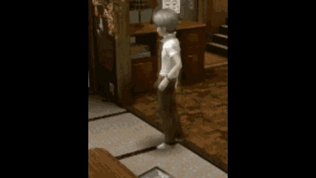 a boy in a white shirt and brown pants is standing in a room