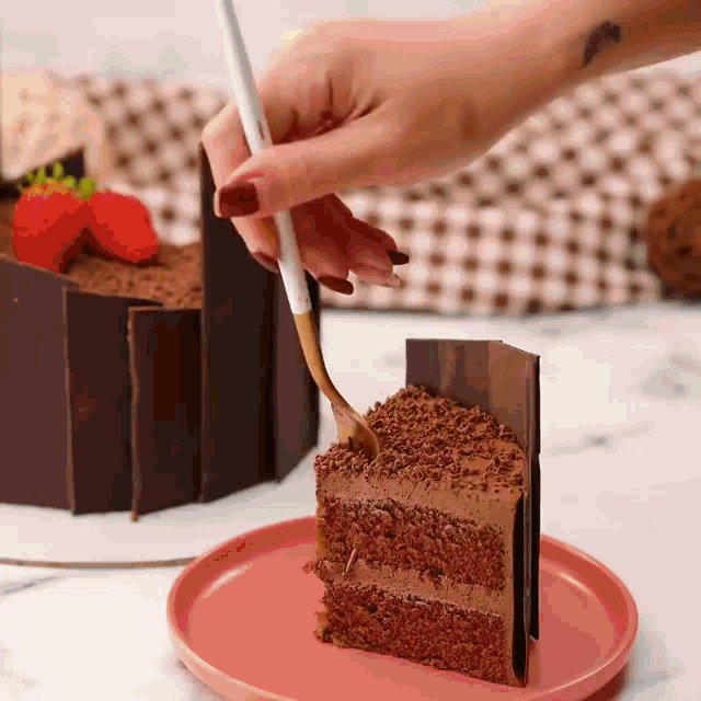 a person is holding a fork over a piece of chocolate cake
