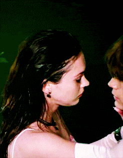 a close up of a woman kissing another woman 's neck