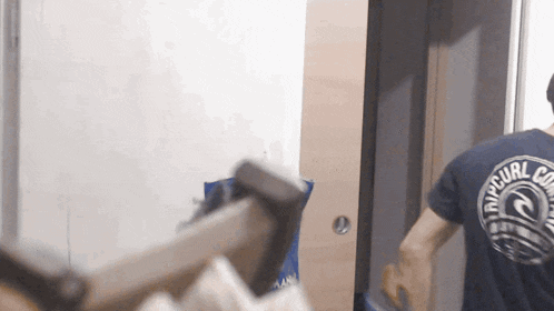 a man wearing a rip curl shirt is looking at himself in the mirror