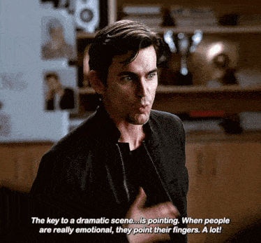 a man in a black jacket is talking about a dramatic scene .