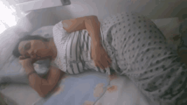 a woman is sleeping on a bed with a blanket that says ' a ' on it