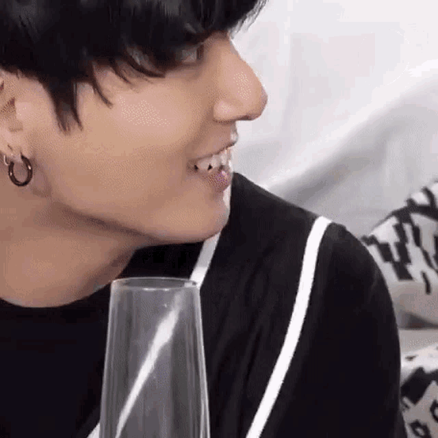 a close up of a person 's face with a glass in his mouth .