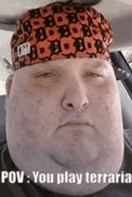 a man with a bandana on his head is sitting in a car with his eyes closed .