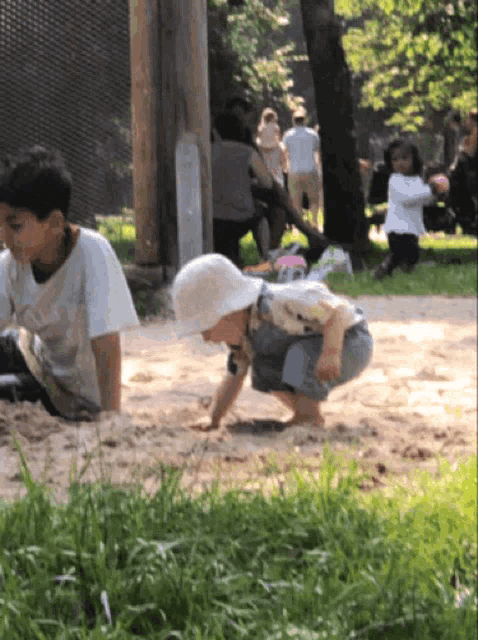 a boy and a girl are playing in the sand