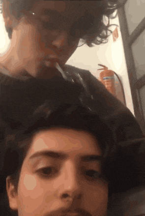 a man is smoking a cigarette next to another man 's head
