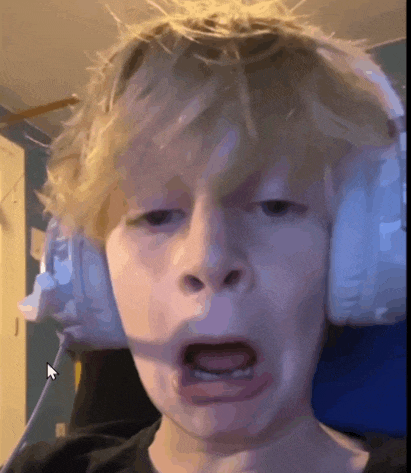 a young boy wearing headphones makes a funny face