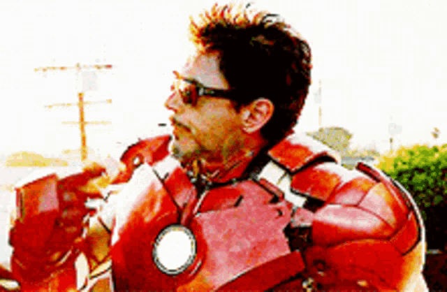 a man in an iron man costume is holding a cup of coffee