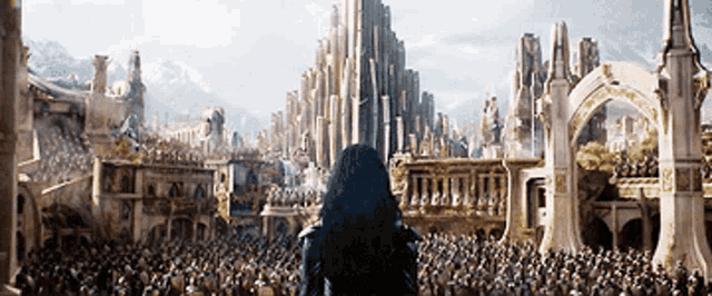 a woman is standing in front of a large crowd of people looking at a city .