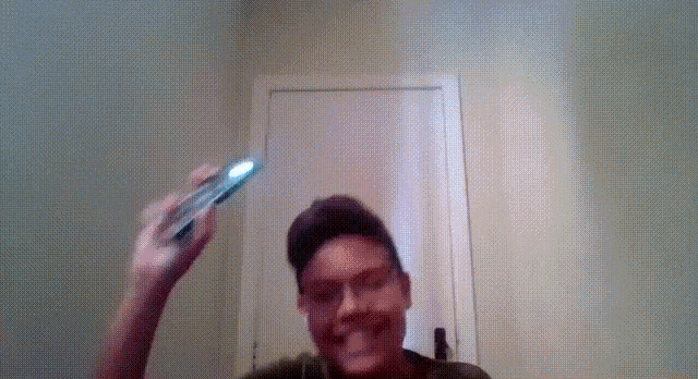 a man is holding a cell phone up in the air
