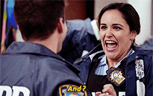 a woman in a police uniform is laughing while talking to a man in a police uniform .