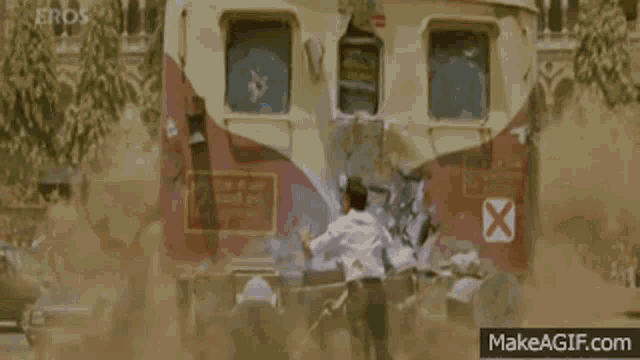 a man is standing in front of a train that has eros written on the side