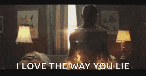 a man is laying on a bed with a fire coming out of his back and says `` i love the way you lie '' .