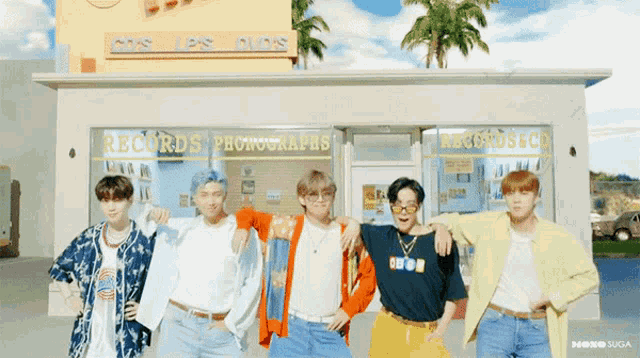 a group of young men are posing in front of a store called records photographs