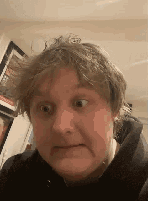 a man making a funny face with a black hoodie on