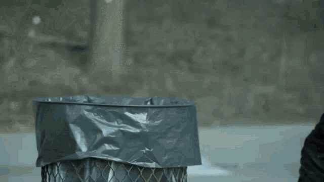 a person is throwing a trash bag with a picture of a girl in it