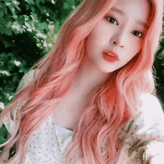 a woman with long pink hair takes a selfie