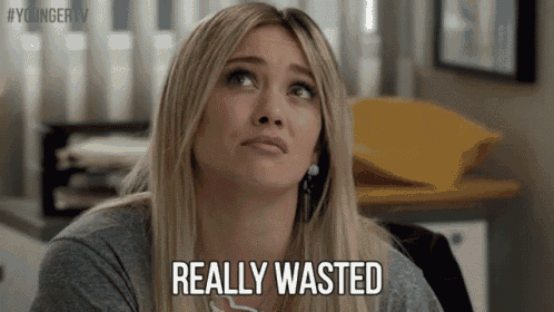 a woman is sitting at a desk and making a face and saying `` really wasted '' .
