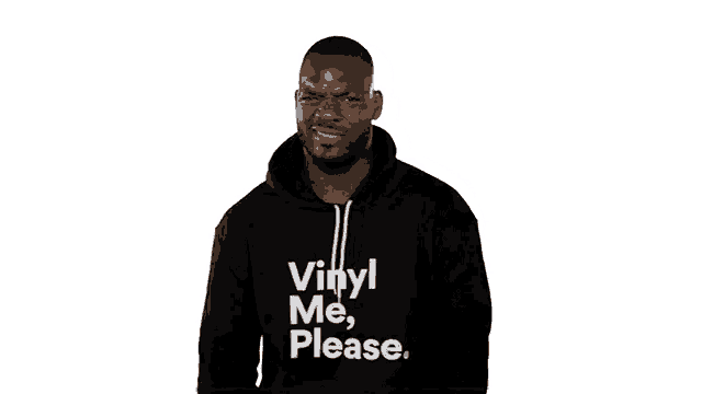 a man wearing a black hoodie that says vinyl me please is making a funny face .