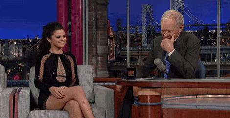 a woman in a black dress is sitting next to a man in a suit .