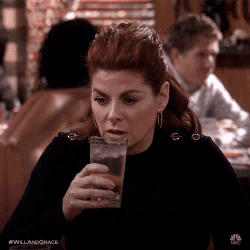 a woman drinking a glass of water with the hashtag #willandgrace on the bottom