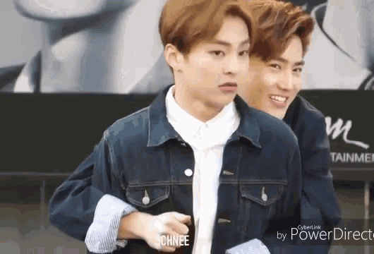 a young man in a denim jacket is standing next to another young man