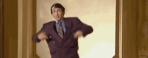 a man in a purple suit and tie is dancing in a hallway .