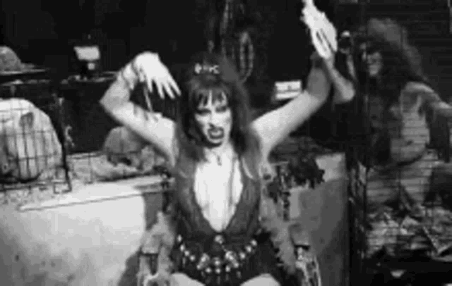 a woman is sitting in a chair with her arms outstretched and a gun in her hand .