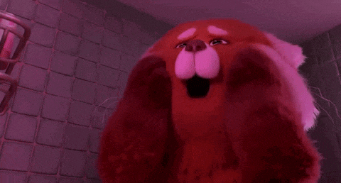 a red panda stuffed animal is making a funny face in a bathroom .