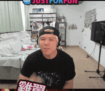 a man wearing headphones and a hat is sitting in front of a sign that says just for fun