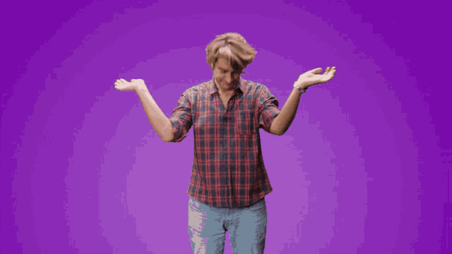a man wearing a plaid shirt and jeans is dancing on a purple background