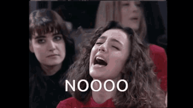 a woman is screaming in front of a group of people while sitting in a chair .