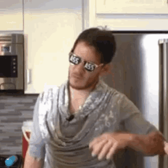 a man wearing sunglasses and a scarf in a kitchen .