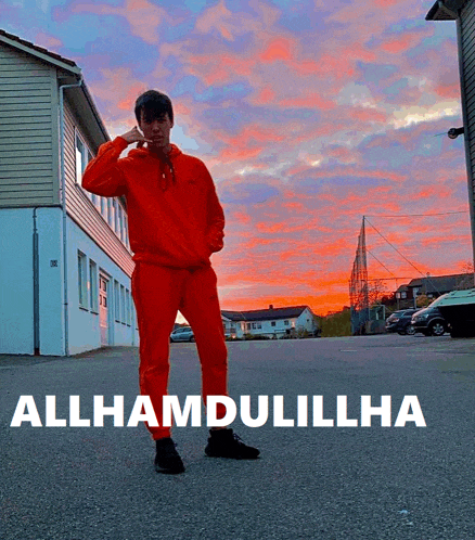 a man in a red outfit is standing in front of a building with the words allhamdulillha on it