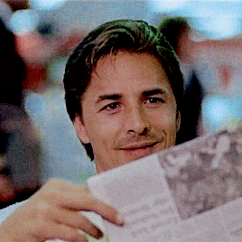 a man is reading a newspaper with a picture of a man on it