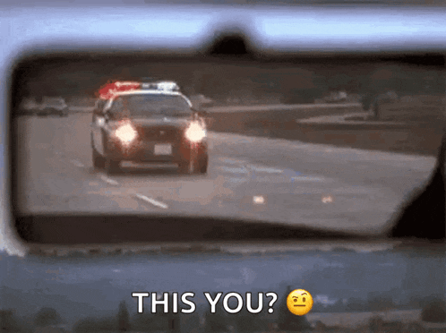 a police car is driving down a highway and the rear view mirror says this you ?