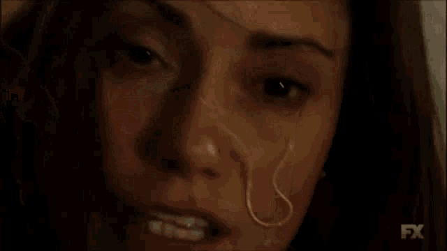 a close up of a woman 's eye with blood coming out of it .