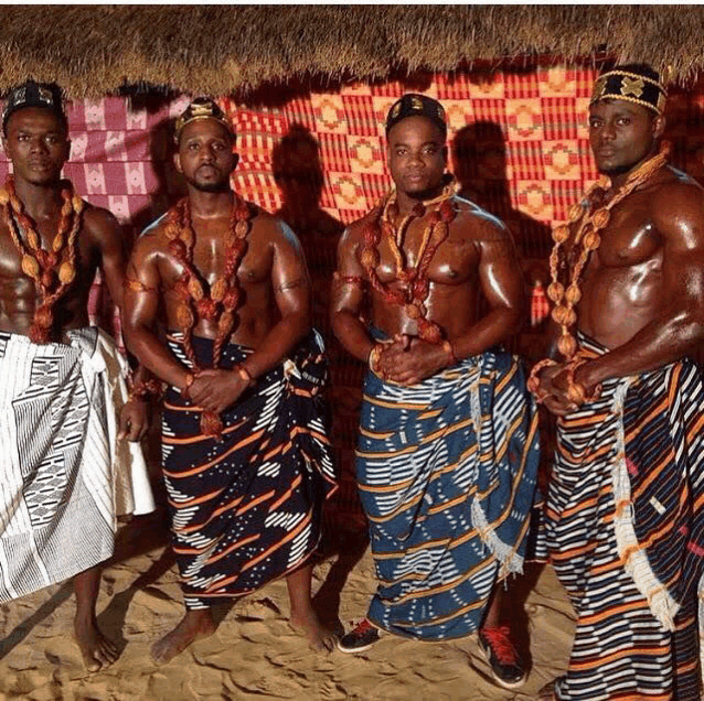 a group of men are posing for a picture and one of them has a necklace that says ' african ' on it