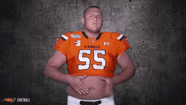 a man wearing a camels jersey holds his belly