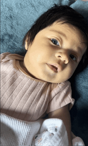 a baby is laying on a blue blanket and looking up at the camera