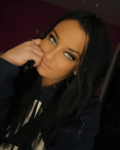 a woman with long black hair and blue eyes is wearing a gap hoodie
