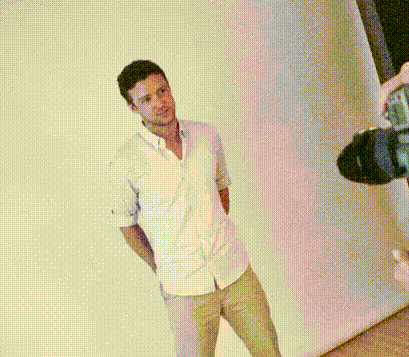 a man in a white shirt and khaki pants is sitting on a chair