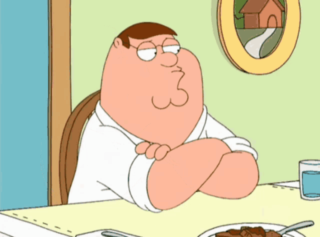 peter griffin sits at a table with his arms crossed