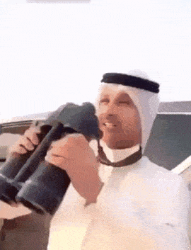 a man is holding a pair of binoculars in his hands .