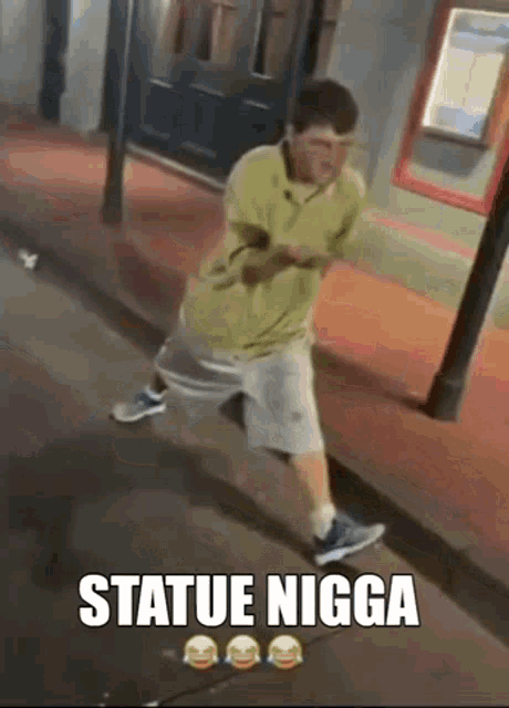 a man standing on a sidewalk with the words " statue nigga " written on it