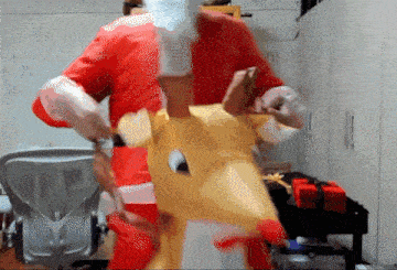 a man in a santa suit is riding on the back of a stuffed reindeer