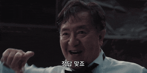 a man wearing a tuxedo and bow tie is smiling in a dark room