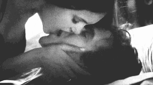 a woman is kissing a man on the cheek in a black and white photo